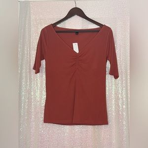 Red (muted tone) top with ruched neck.